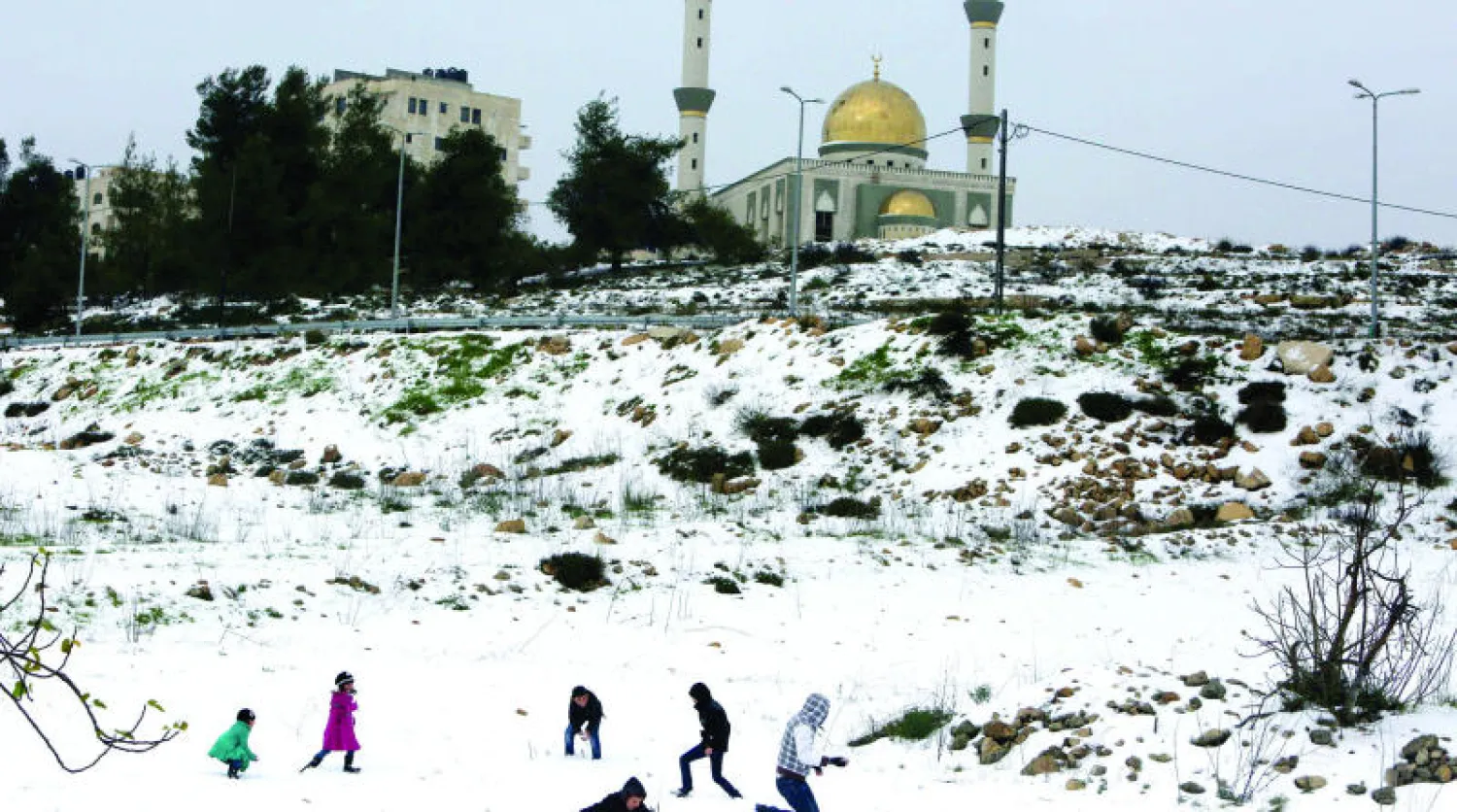 أطفال فلسطينيون يلعبون بعد تساقط الثلوج في رام الله أمس (أ.ف.ب)