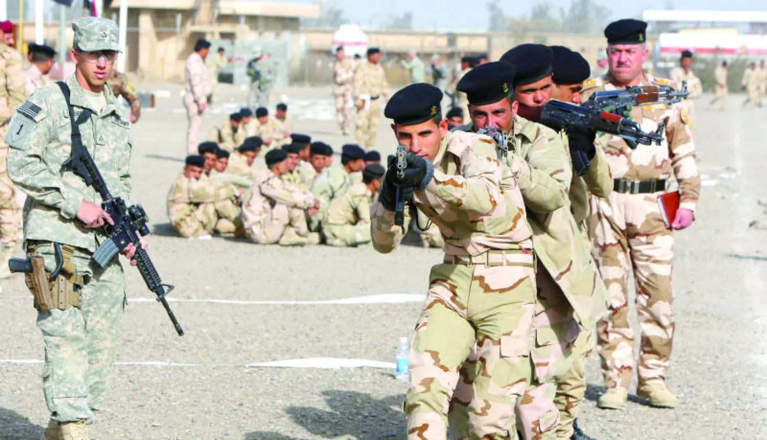 مدرب عسكري أميركي يدرب جنودا عراقيين على احتلال وإخلاء مبان في معسكر تاجي شمال العاصمة بغداد (أ.ف.ب)