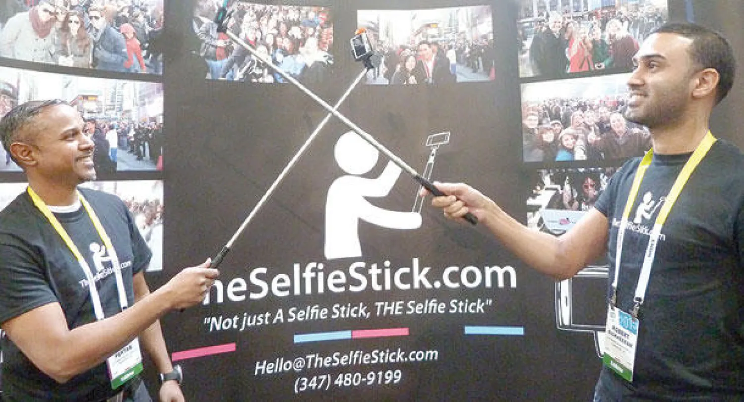 روبرت ريكيرام وآندريه بيرتاب اللذان أسسا شركة تصنع «عصا السيلفي» خلال مشاركتهم  في معرض لاس فيغاس أمس (أ.ف.ب)