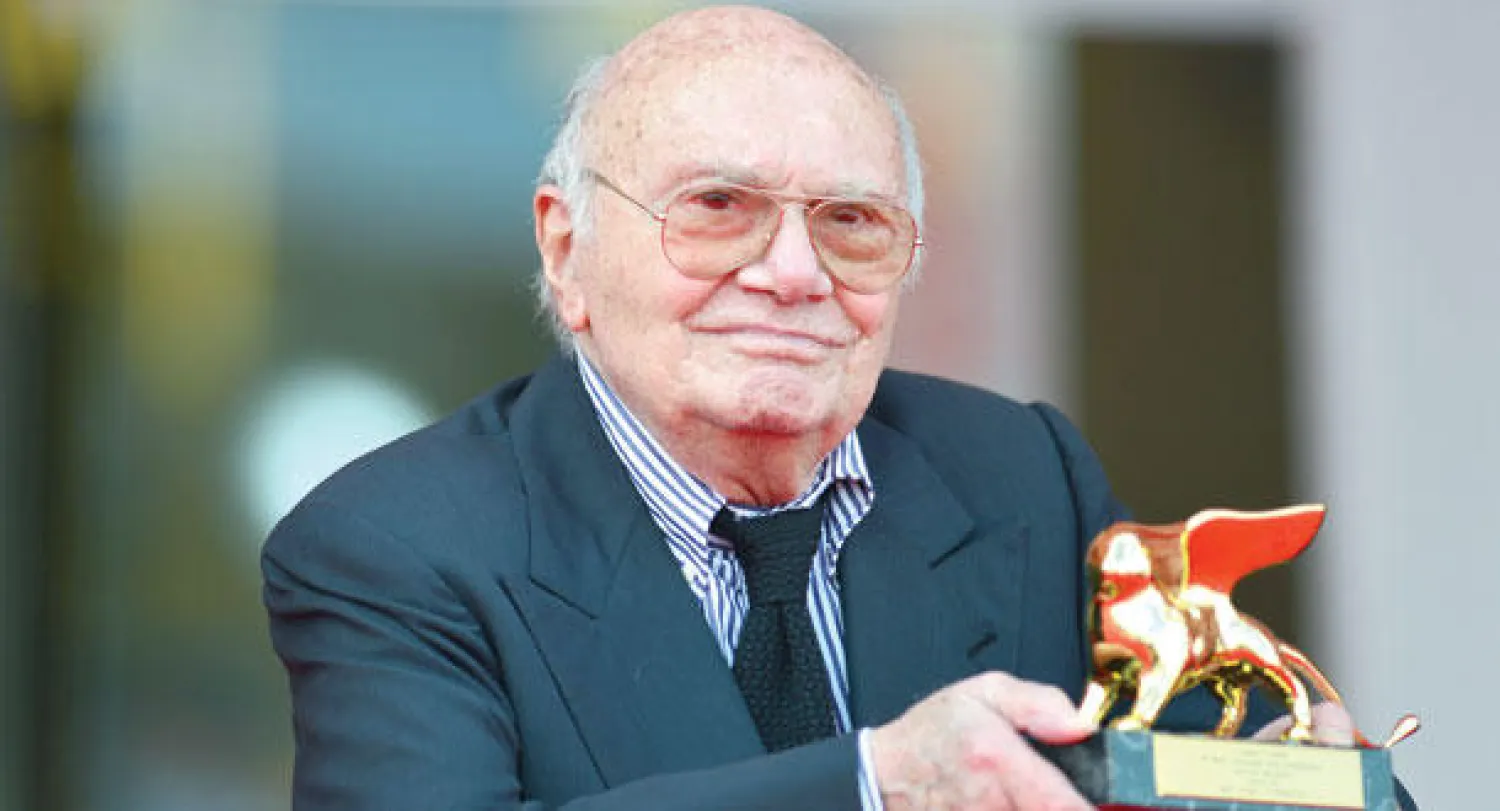 صورة أرشيفية للراحل تعود لعام 2012 مع جائزة الأسد الذهبي لمهرجان فينيسيا على مجمل أعماله (أ.ف.ب)