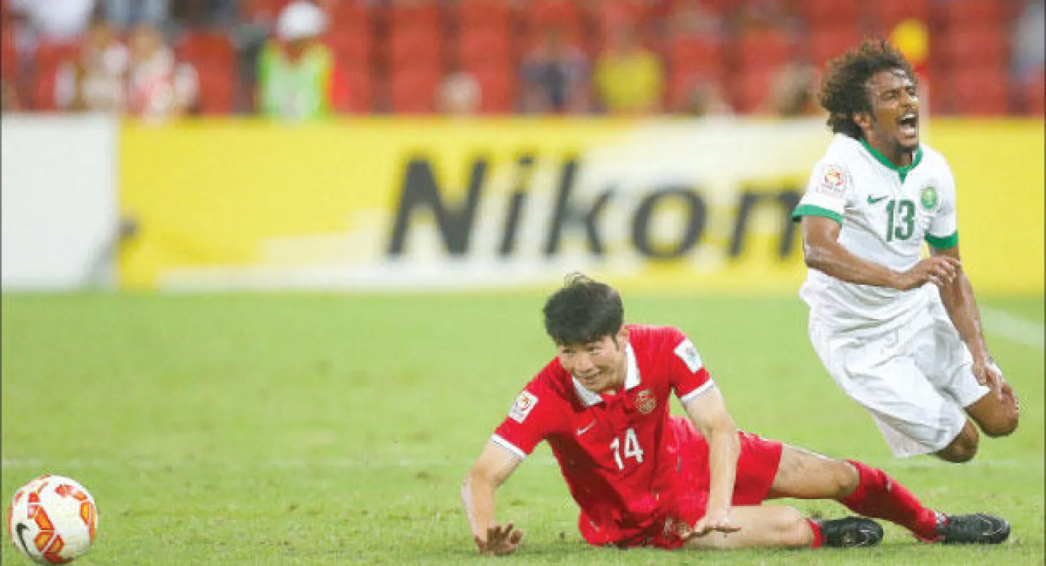 ياسر الشهراني يتعرض للمخاشنة في إحدى الهجمات الخضراء (أ.ف.ب)