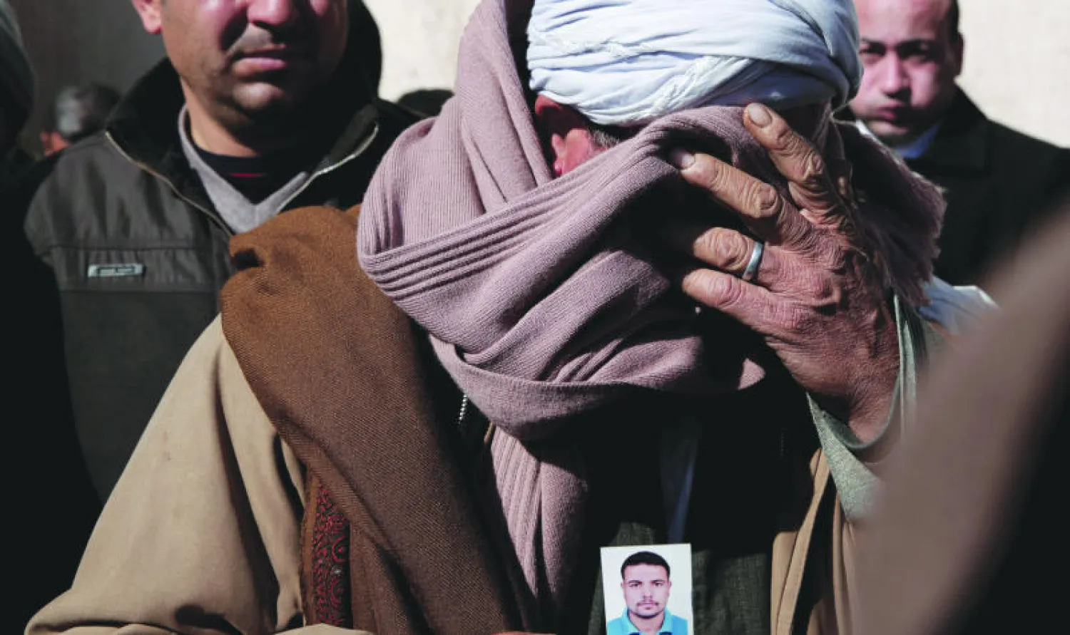 سمير مجيد وهو قبطي مصري يبكي أمام وزارة الخارجية المصرية الأسبوع الماضي حاملا صورة نجله جرجس سمير الذي اختطف في ليبيا (أ.ب)