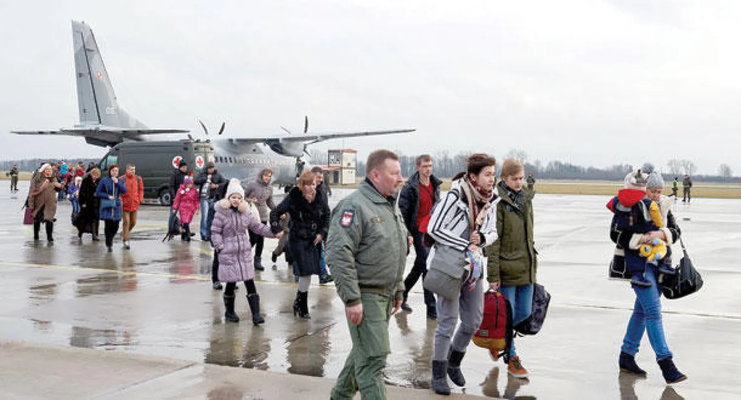 لاجئون أوكرانيون من أصول بولندية يصلون إلى بولندا من شرق أوكرانيا حيث استقبلت وارسو أمس 178 منهم (إ.ب.أ)