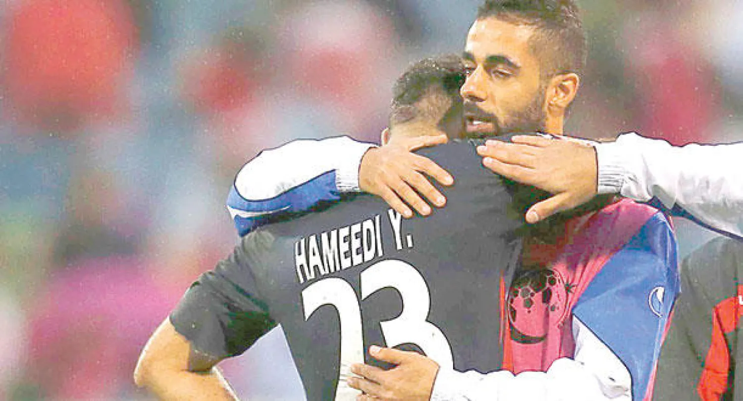 لاعبو الكويت يواسون بعضهم بعضا بعد الخروج من النهائيات الآسيوية (رويترز)