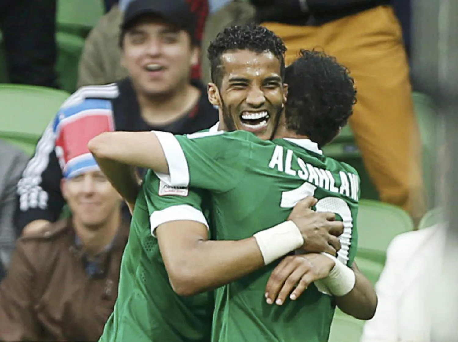 هزازي والسهلاوي يتعانقان بعد الهدف الثاني للأخضر في شباك كوريا (رويترز)