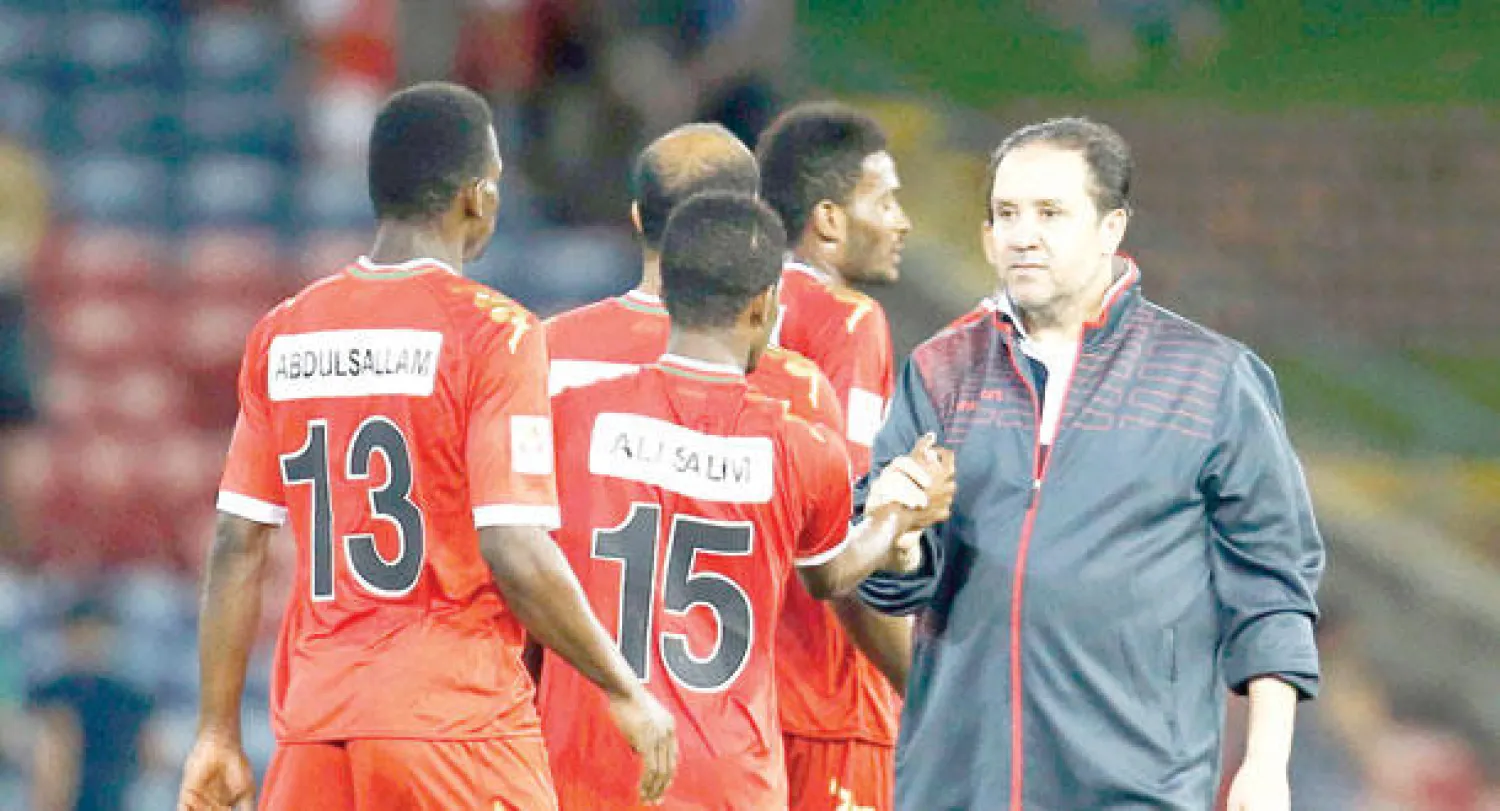 نبيل معلول يبارك للاعبي عمان الفوز أمس (رويترز)