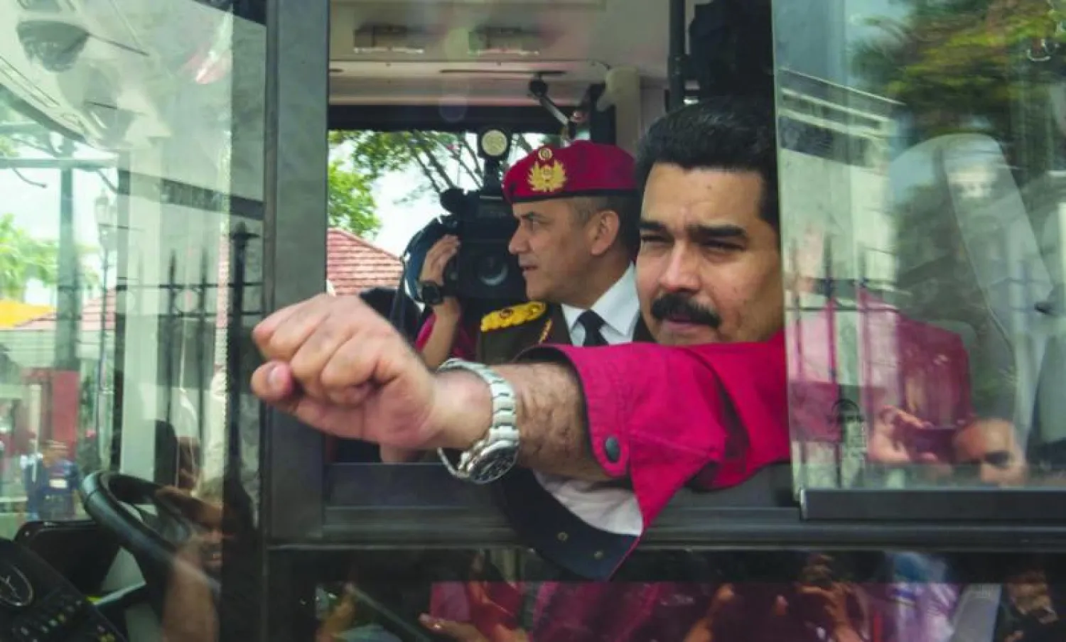 الرئيس الفنزويلي يلوح لمؤيديه وهو يقود حافلة لدى عودته الى كاراكاس (أ.ف.ب)