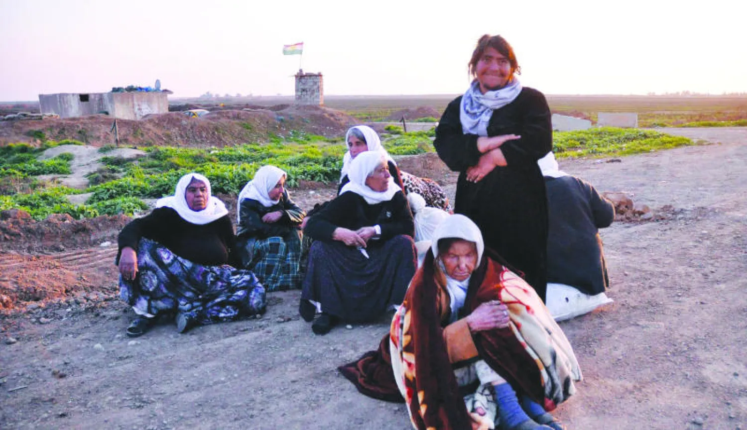 إيزيديات يجلسن عند نقطة تفتيش قرب كركوك بعد أن أفرج عنهن تنظيم داعش أول من أمس (إ.ب.أ)