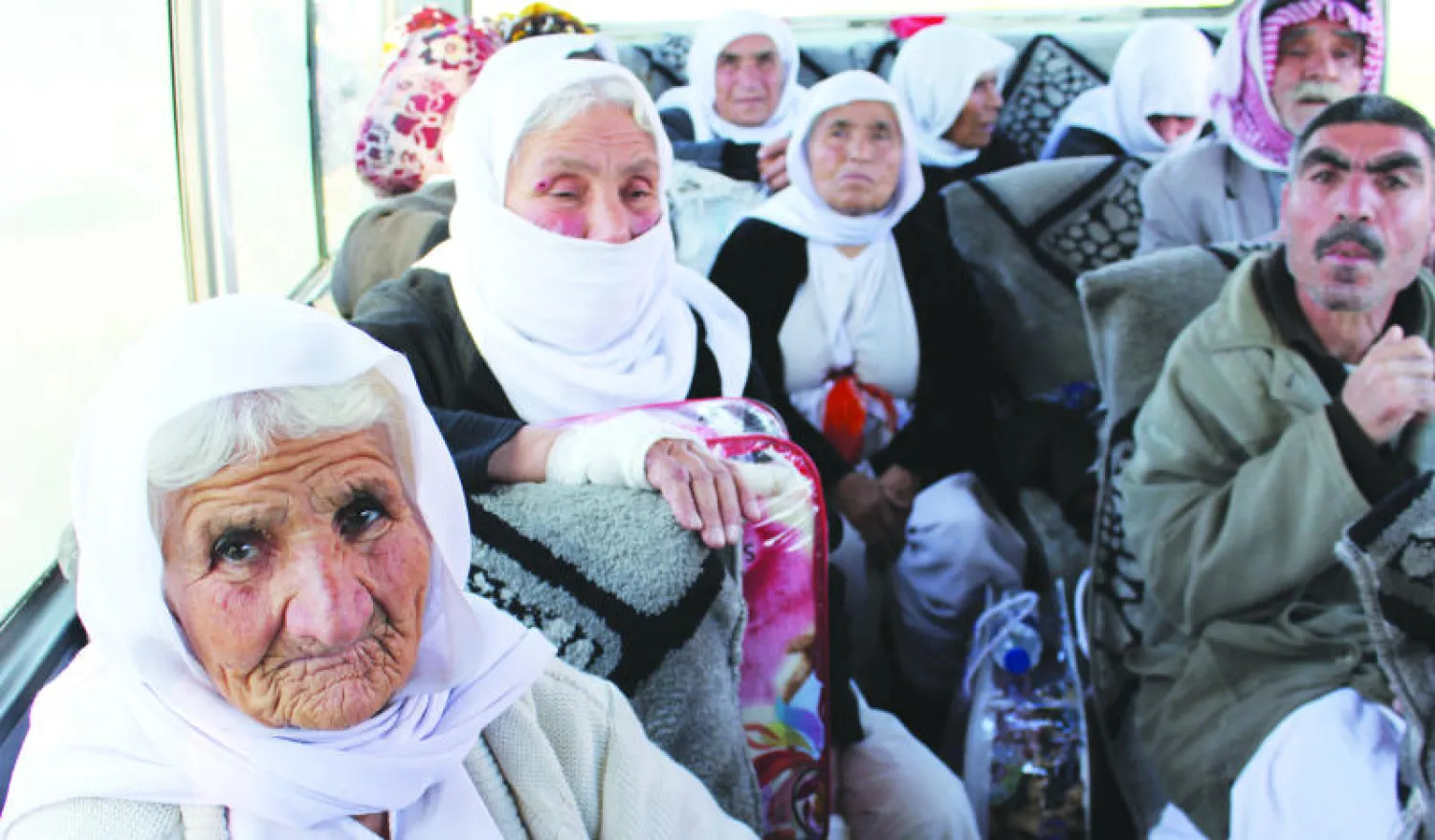 إيزيديون أفرج عنهم «داعش» مؤخرا في حافلة تنقلهم إلى دهوك أمس («الشرق الأوسط»)