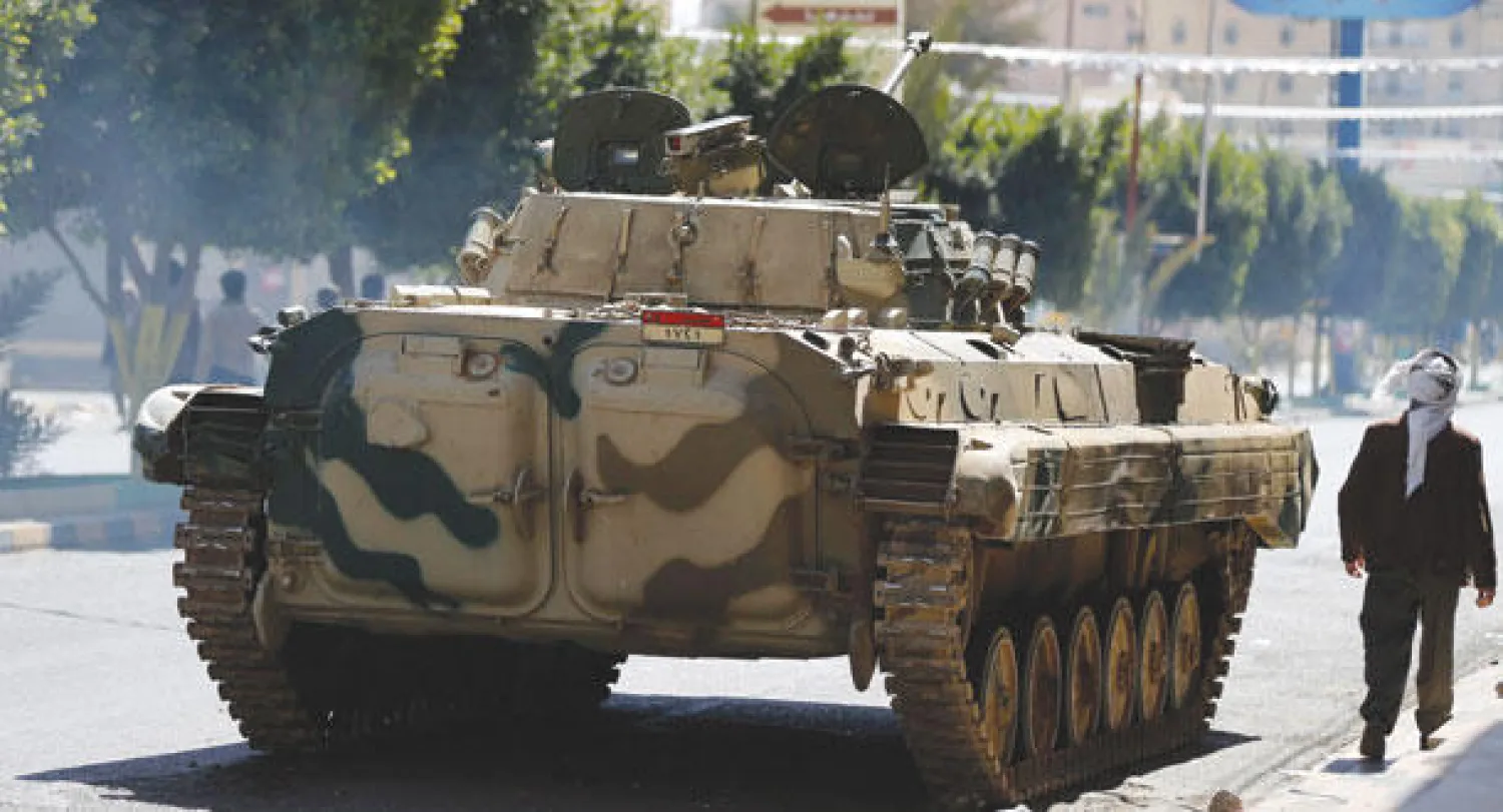 مدرعة عسكرية تابعة لجماعة الحوثي في شارع يقود إلى القصر الرئاسي أثناء الاشتباكات في العاصمة اليمنية صنعاء أمس (رويترز)