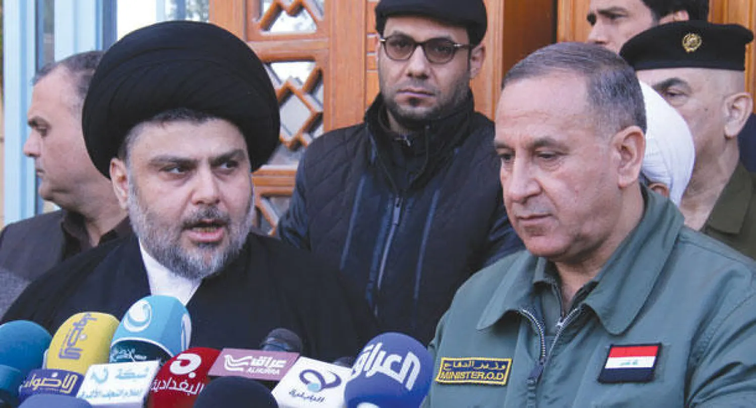 زعيم التيار الصدري مقتدى الصدر ووزير الدفاع العراقي خالد العبيدي خلال مؤتمر صحافي مشترك في النجف أمس (إ.ب.أ)