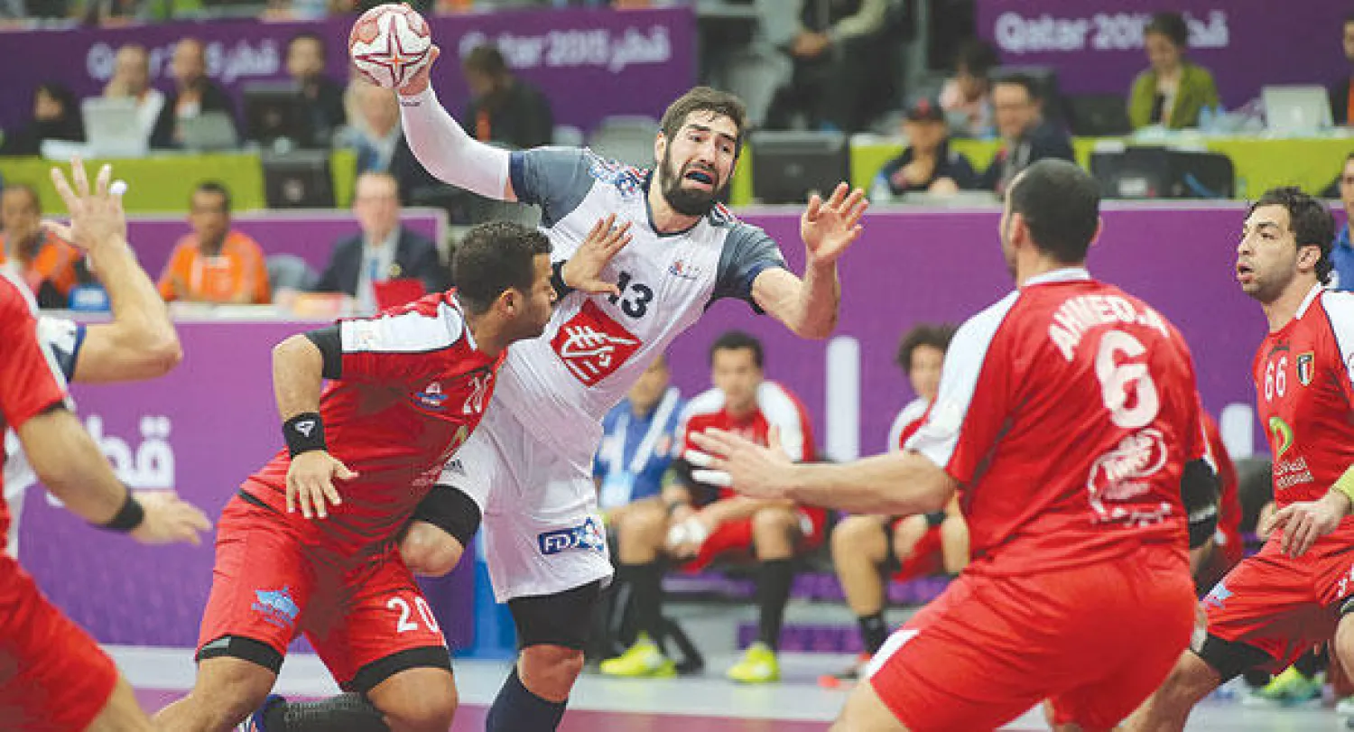 نيكول لاعب فرنسا يحاول التصويب رغم حصار الدفاع المصري (أ.ف.ب)