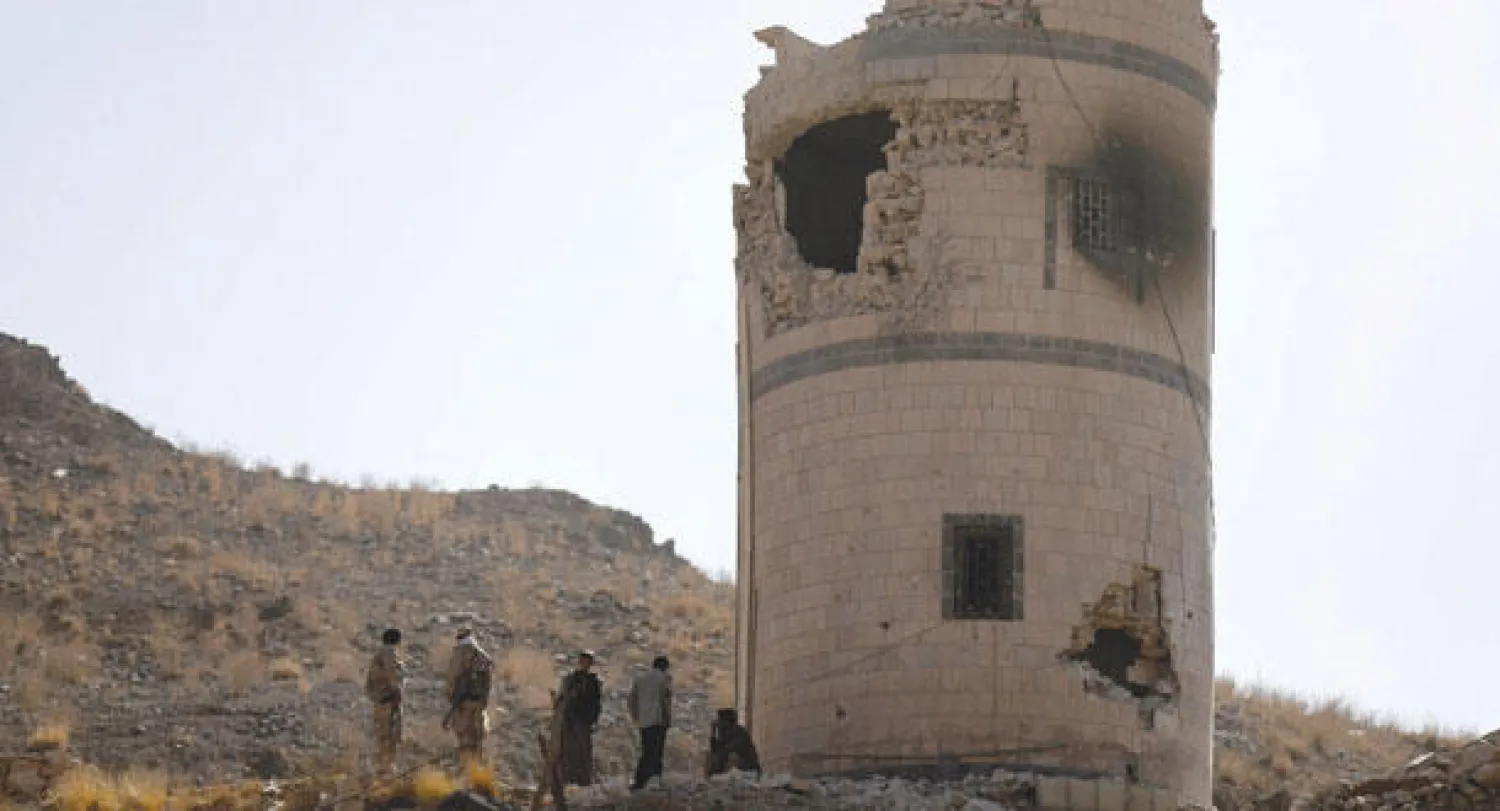 مقاتلون حوثيون يقفون أمام أحد أبراج المراقبة التي استهدفت أثناء هجومهم على دار الرئاسة في صنعاء أمس (رويترز)