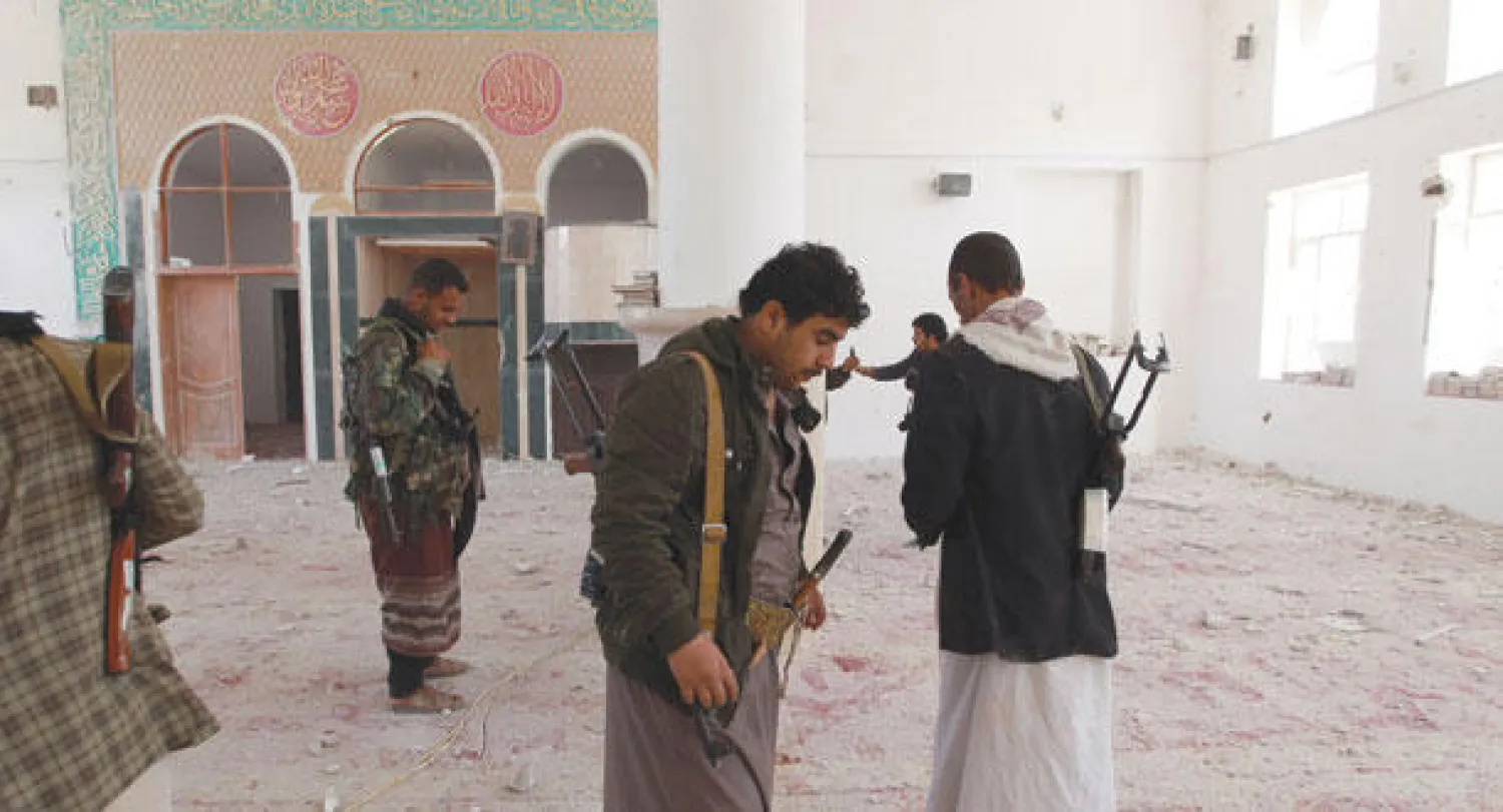 عناصر من المقاتلين الحوثيين يجولون في مسجد تعرض لتدمير على أثر المواجهات التي شهدتها صنعاء (أ.ف.ب)