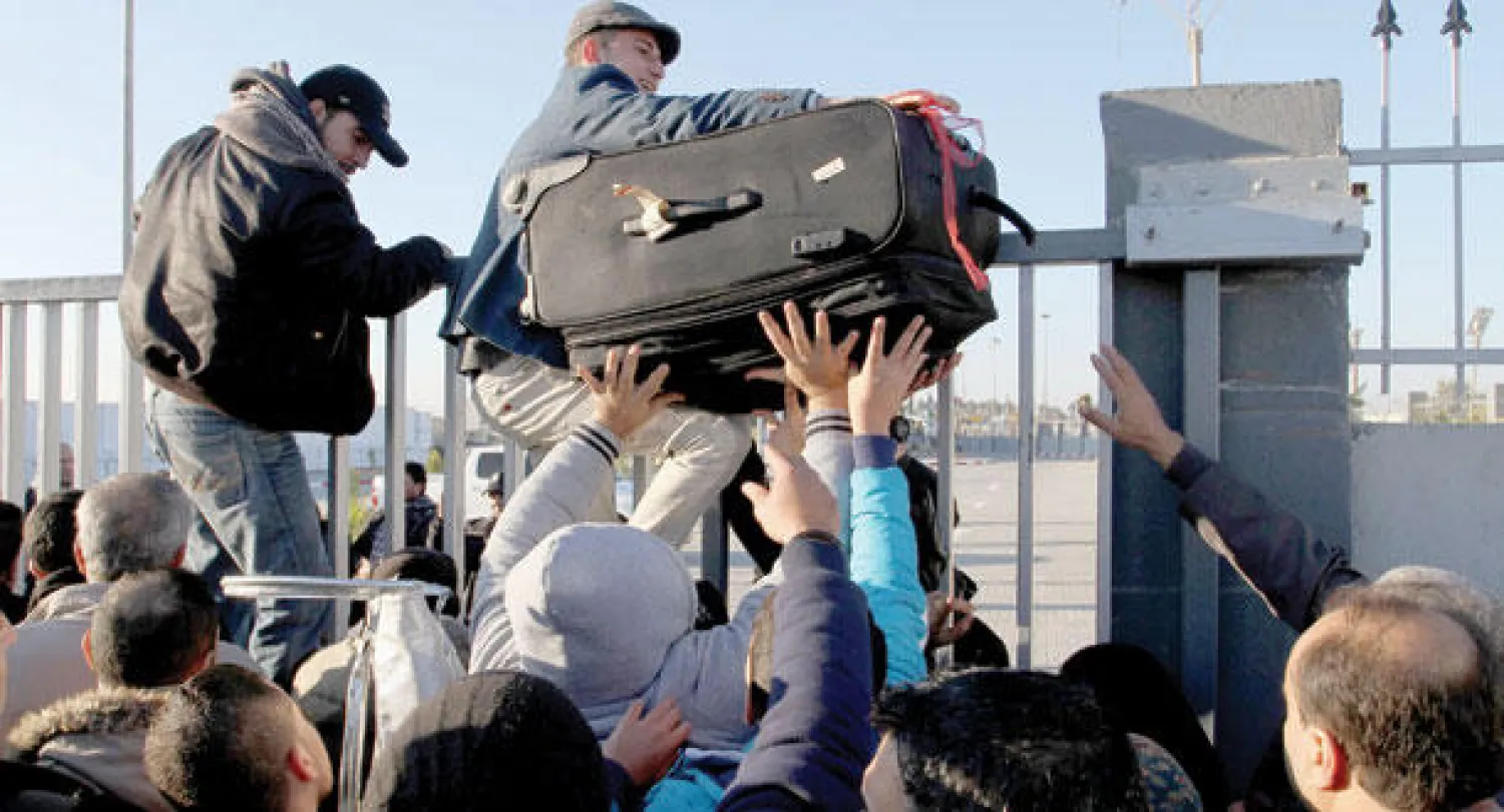 فلسطينيون يحاولون العبور إلى الجانب المصري عبر معبر رفح بعد فتحه لثلاثة أيام أمس (غيتي)