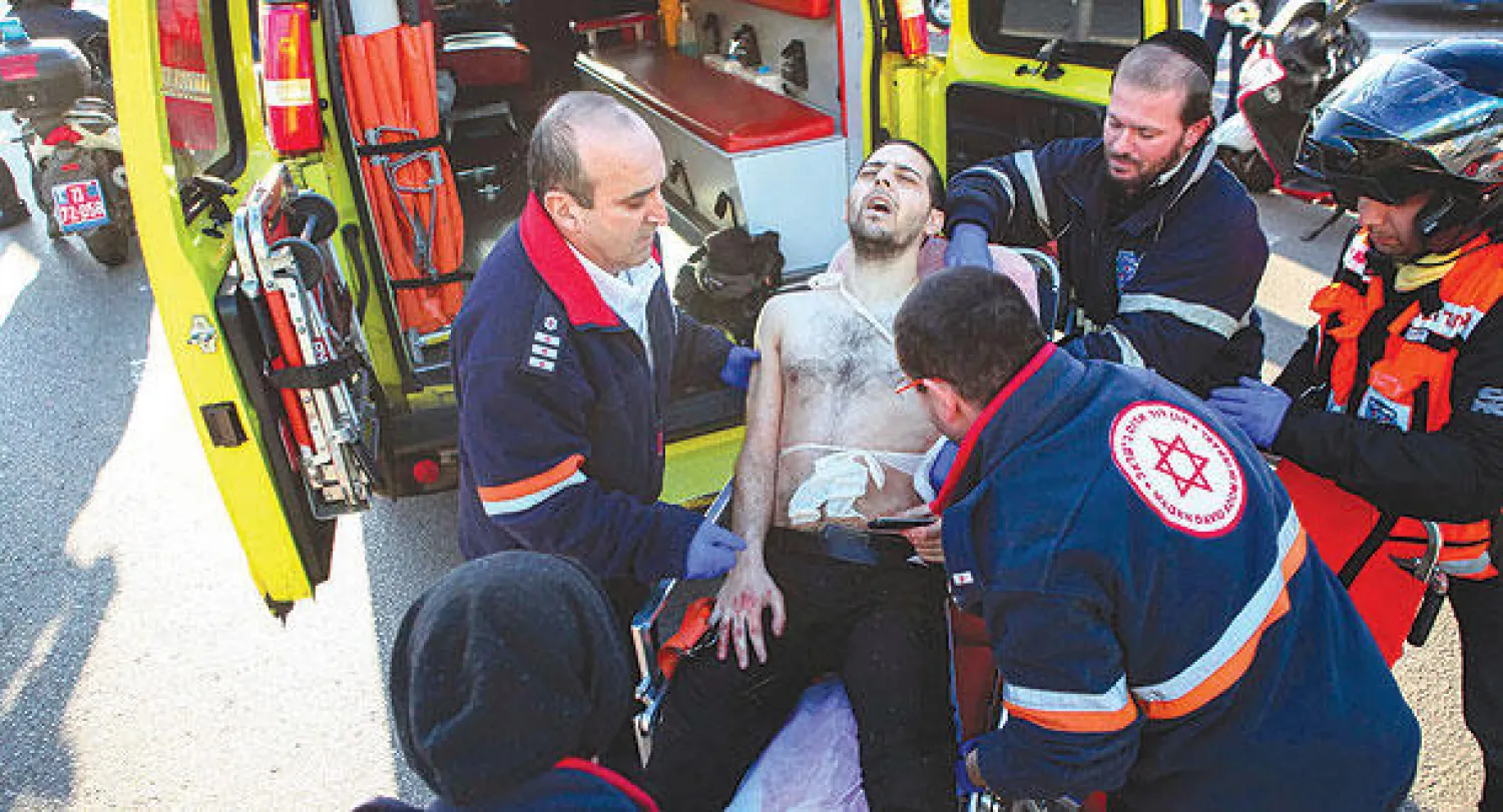 ممرضون يقدمون الإسعافات الأولية لأحد المصابين في الهجوم الذي نفذه الفلسطيني حمزة محمد المتروك على ركاب حافلة في تل أبيب أمس (رويترز)