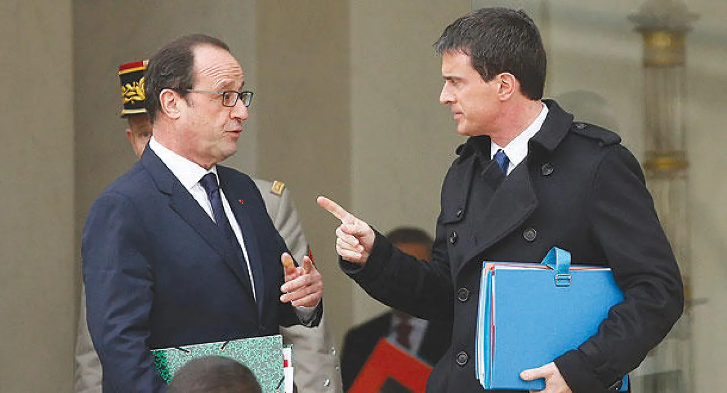 الرئيس الفرنسي هولاند في حديث جانبي مع رئيس الوزراء مانويل فالس عقب اجتماع لمجلس الأمن الفرنسي حول الإرهاب في باريس أمس (إ.ب.أ)