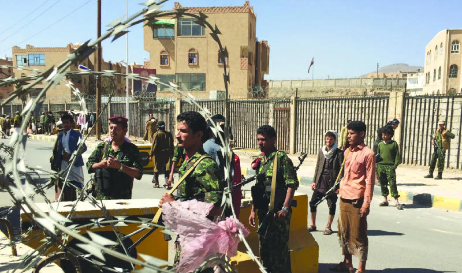 حوثيون يرتدون الزي العسكري أمام دار الرئاسة في صنعاء أمس (أ.ف.ب)