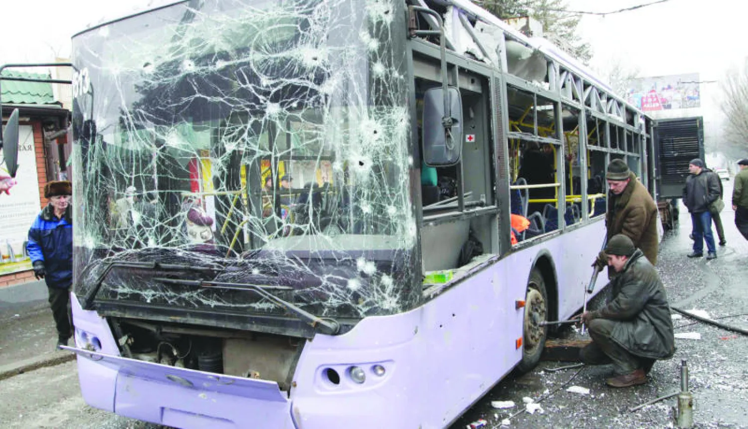 أوكرانيون يفحصون حافلة طالها انفجار في مدينة دونيتسك بشرق أوكرانيا أمس (رويترز)