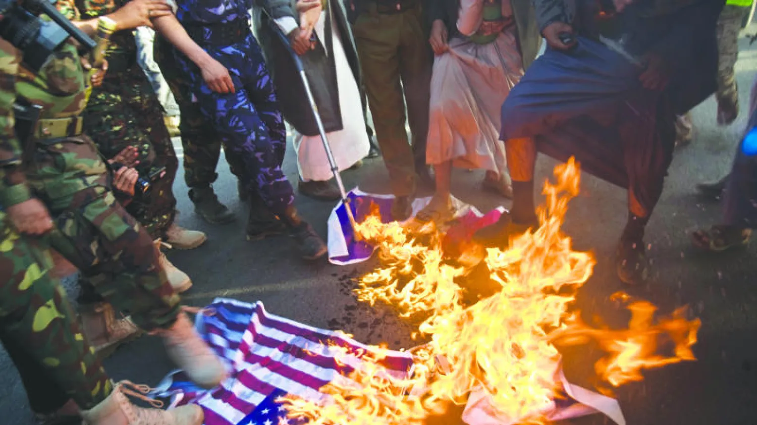 حوثيون يحرقون العلم الأميركي ويدوسون عليه أثناء مظاهرات قاموا بها الجمعة الماضي في صنعاء 2015 (أ.ب)