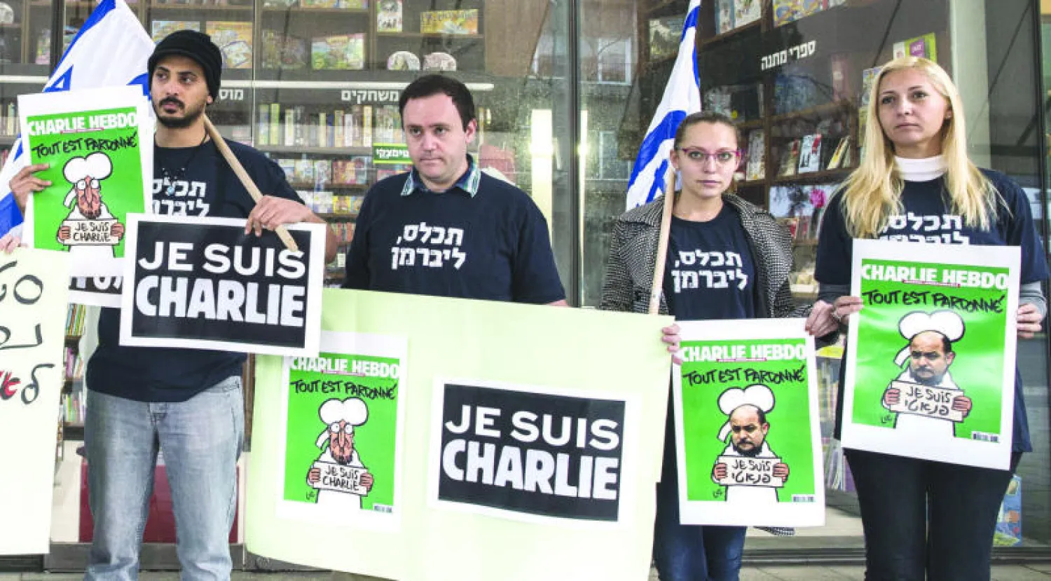 يمينيون إسرائيليون مؤيدون لنشر مجلة {شارلي إيبدو} في تل أبيب أمس (أ.ف.ب)