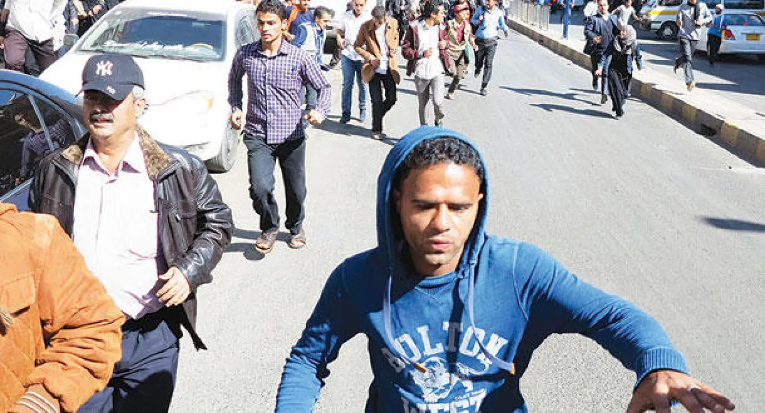 متظاهرون يمنيون يفرون بعد مطاردتهم من قبل عناصر الحوثيين في صنعاء أمس (رويترز)