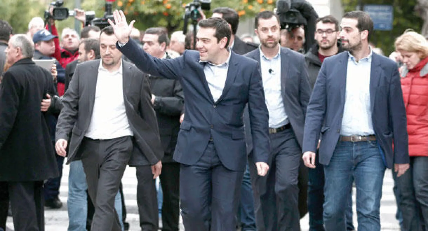 تسيبراس يوجه تحية بيده أثناء وصوله لأداء القسم في القصر الرئاسي بأثينا (رويترز)