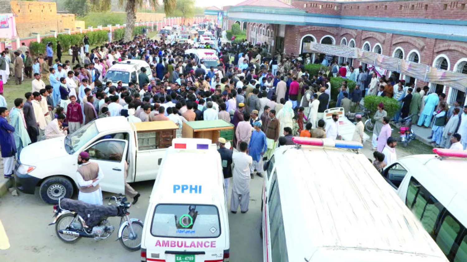 سيارات الإسعاف ومواطنون خارج مسجد مدينة شيكاربور الباكستانية الذي تعرض لتفجير انتحاري أثناء صلاة الجمعة أمس (إ.ب.أ)