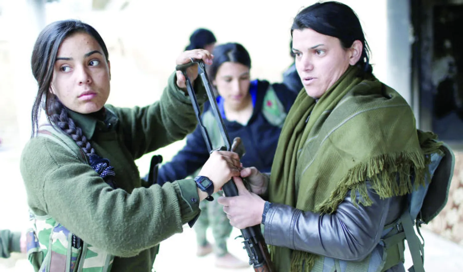 دورية نسائية مقاتلة لوحدات الدفاع الكردية في كوباني التي تقع على مقربة من الحدود السورية تستعد للخروج من المنطقة أمس بعد انسحاب «داعش» (إ.ب.أ)