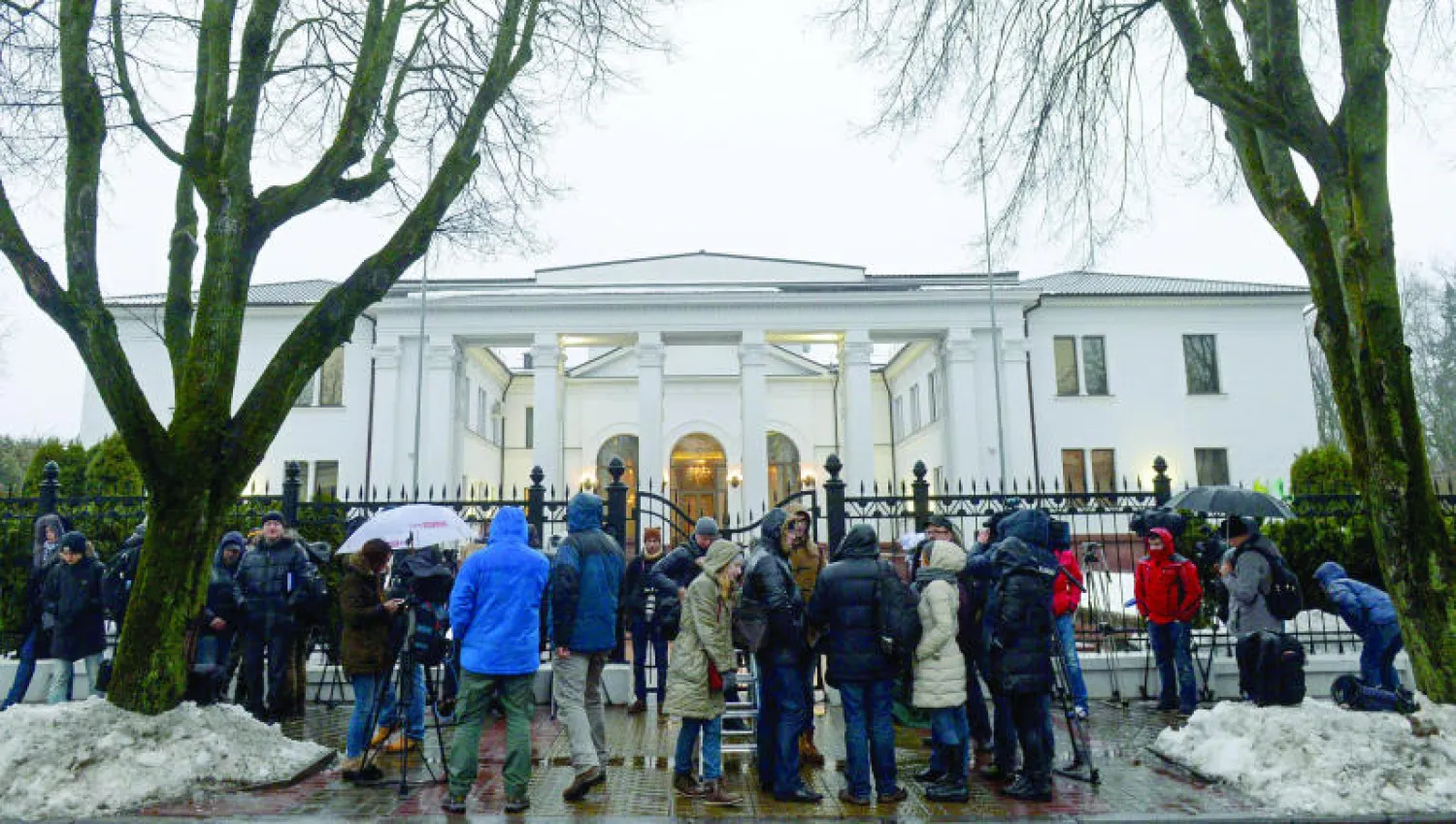 صحافيون ينتظرون خارج القصر الرئاسي في مينسك حيث انطلقت محادثات السلام بين الأطراف المعنية بالأزمة الأوكرانية أمس (أ.ف.ب)