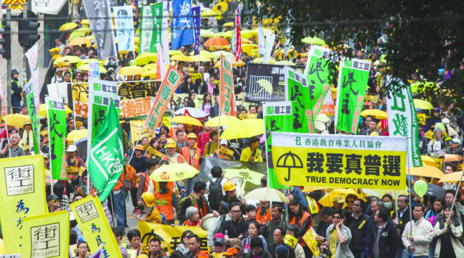 متظاهرون يسيرون وسط هونغ كونغ أمس (إ.ب.أ)