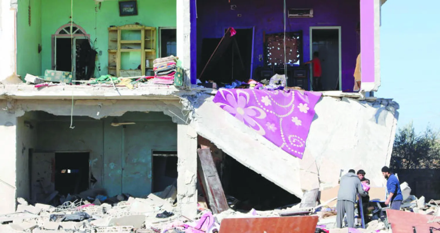 سكان منزل مدمر بقرية صيدا بريف درعا يعاينون ما تبقى من حاجياتهم بعد قصف لطيران النظام (رويترز)