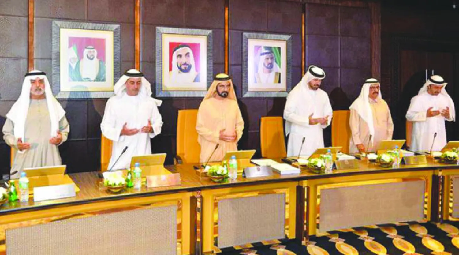 الشيخ محمد بن راشد آل مكتوم يتوسط أعضاء الحكومة الإماراتية وهم يقرأون الفاتحة على روح الملك الراحل عبد الله بن عبد العزيز (وكالة الأنباء الإماراتية)