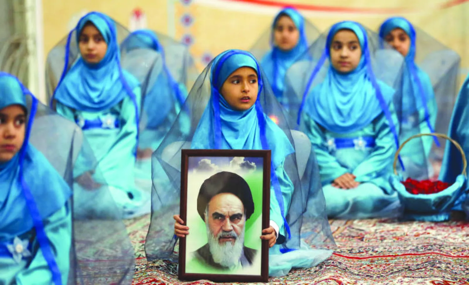 طفلة إيرانية تحمل صورة لآية الله الخميني في احتفالية أمس لإحياء الذكرى الـ36 لعودته من المنفى إلى طهران (أ.ف.ب)