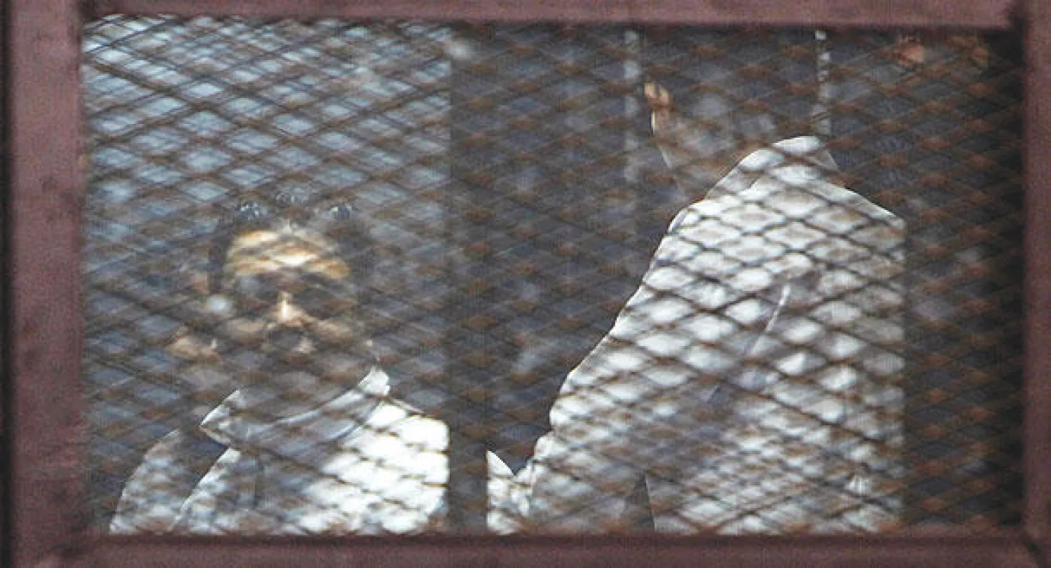 اثنان من أنصار الإخوان خلف القضبان في محكمة جنايات الجيزة في جلستها المنعقدة أمس،  برئاسة المستشار محمد ناجي شحاتة، والتي قضت بمعاقبة 183 متهما بالإعدام شنقا (رويترز)