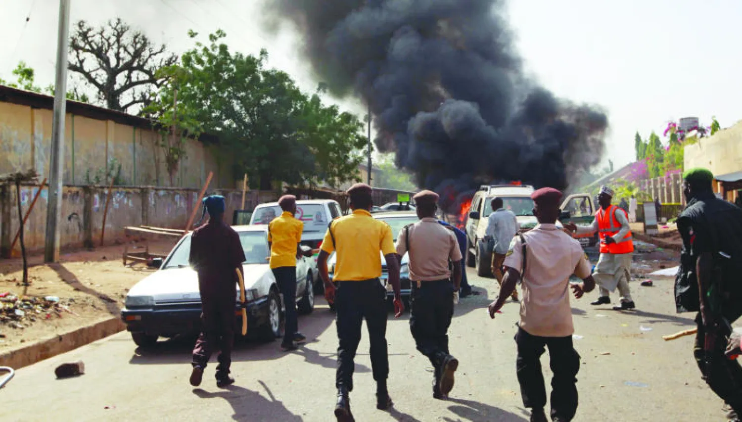 رجال أمن يتوجهون إلى موقع التفجير بالقرب من ملعب رياضي بمدينة غومب النيجيرية أمس (رويترز)