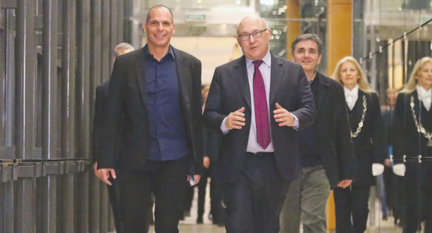 وزير المالية اليوناني يانيس فاروفاكيس خلال لقائه نظيره الفرنسي ميشيل سابين في باريس أمس (أ.ب)