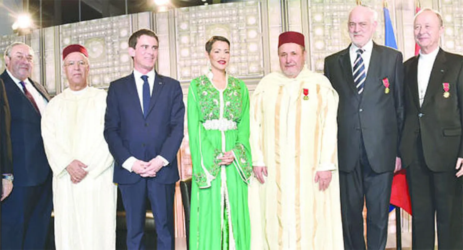 الأميرة للا مريم شقيقة الملك محمد السادس ومانويل فالس رئيس الوزراء الفرنسي خلال حفل تسليم أوسمة ملكية لممثلي الديانات الثلاث في فرنسا مساء أمس في باريس (ماب)