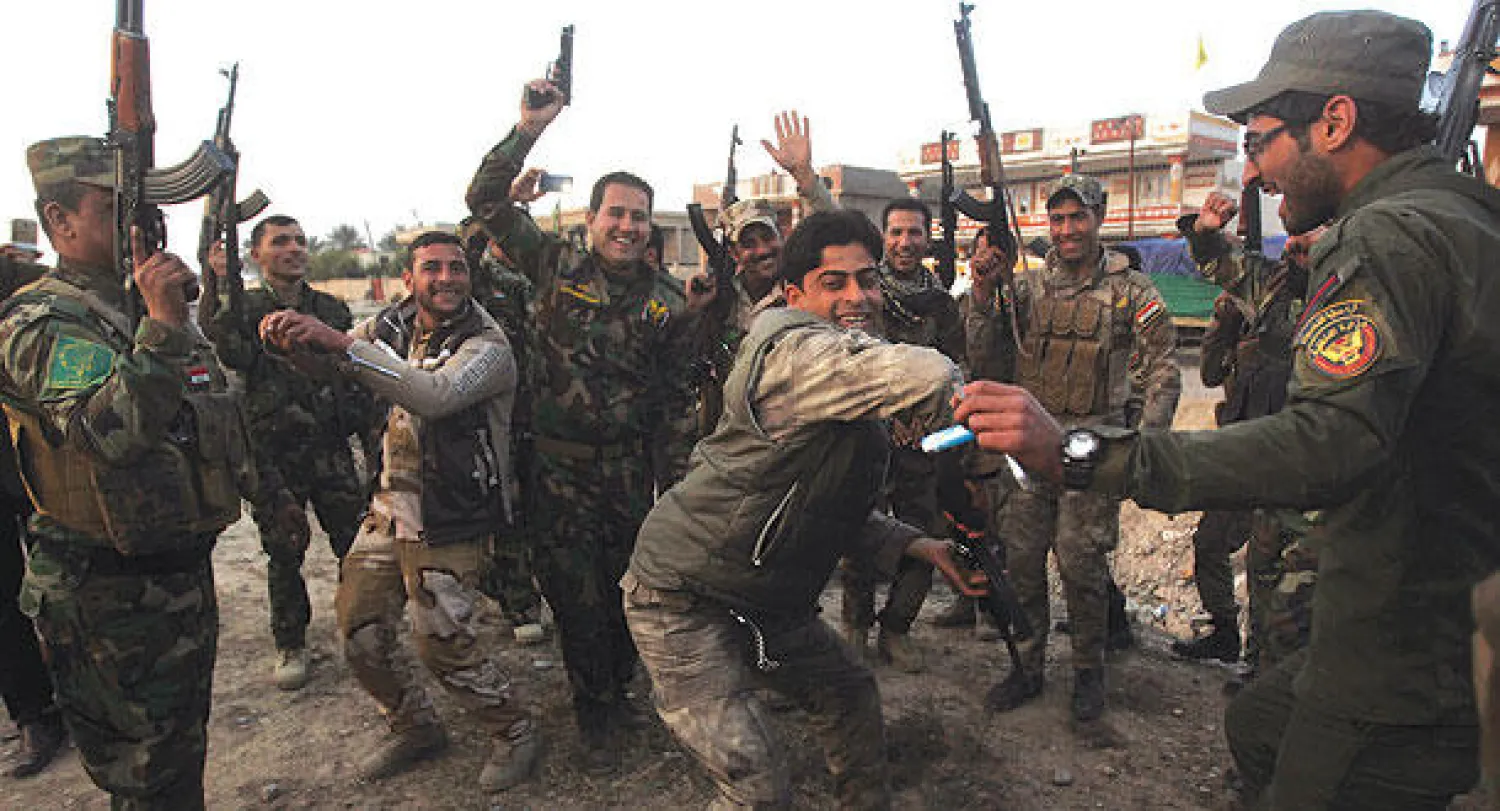 صورة بثت أمس لعناصر في الحشد الشعبي وهم يحتفلون بعد استعادتهم منطقة المنصورية في محافظة ديالى من «داعش» أول من أمس (أ.ف.ب)