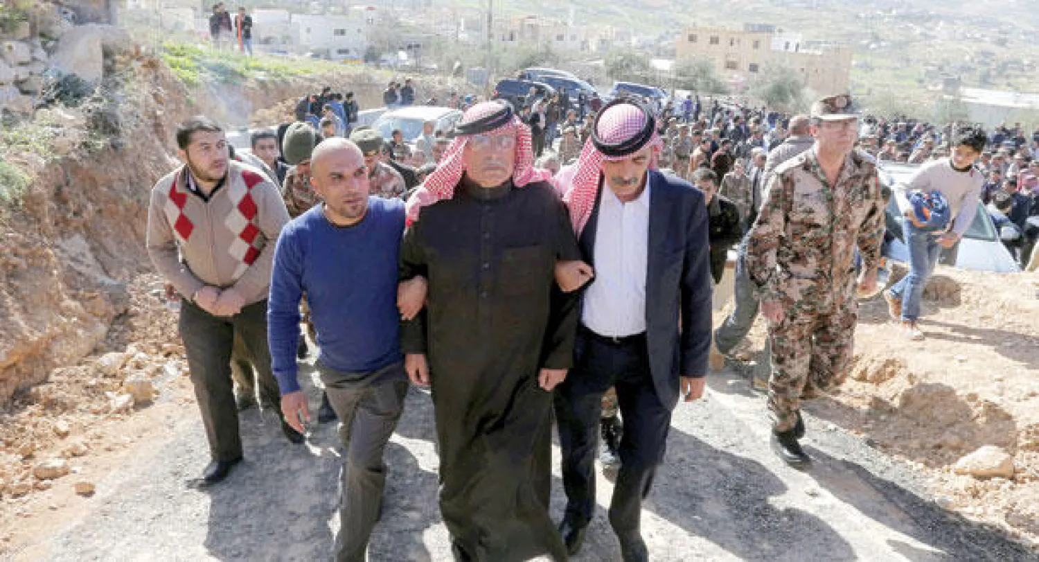 والد الطيار الأردني معاذ الكساسبة محاطا بأفراد عائلته والقوات المسلحة أثناء توجهه لمجلس العزاء في مدينة الكرك أمس (أ.ف.ب)