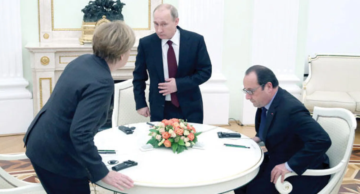 بوتين أثناء اجتماعه مع هولاند وميركل في الكرملين أمس (إ.ب.أ)