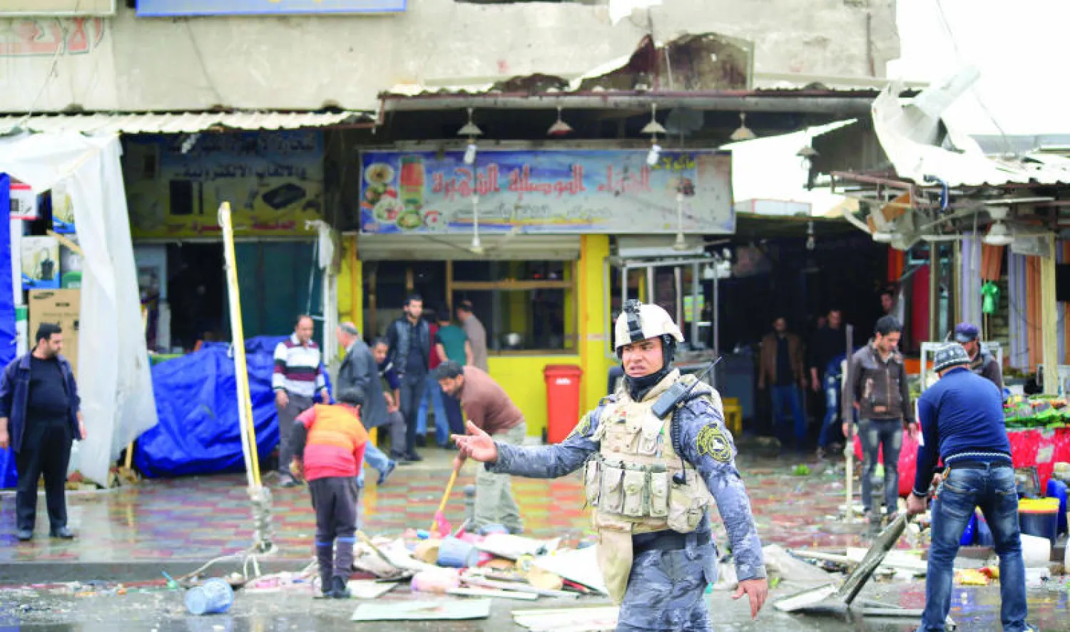 عناصر أمن في مكان تفجير في بغداد أمس (رويترز)