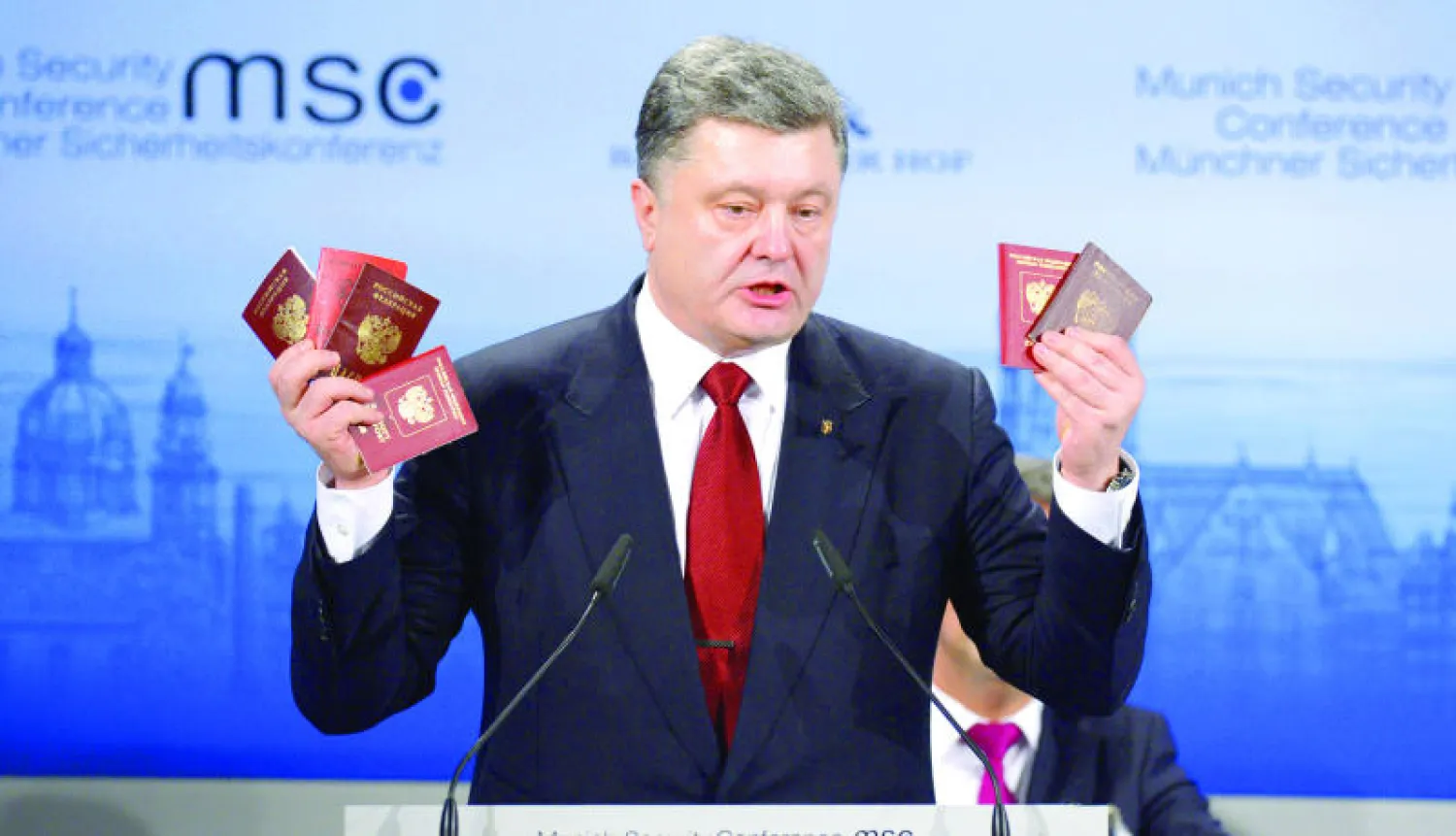 الرئيس الأوكراني بوروشينكو يعرض في ميونيخ أمس جوازات سفر تعود إلى جنود روس قال إنهم دخلوا الى أوكرانيا للقتال إلى جانب المتمردين (أ.ف.ب)