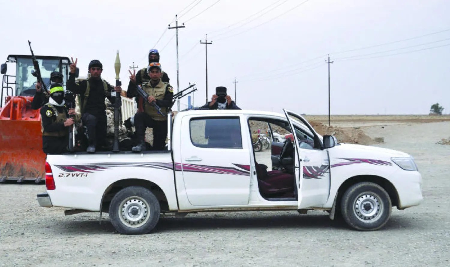 عناصر في الحشد الشعبي في طريقهم إلى داقوق قرب تكريت أمس (إ.ب.أ)