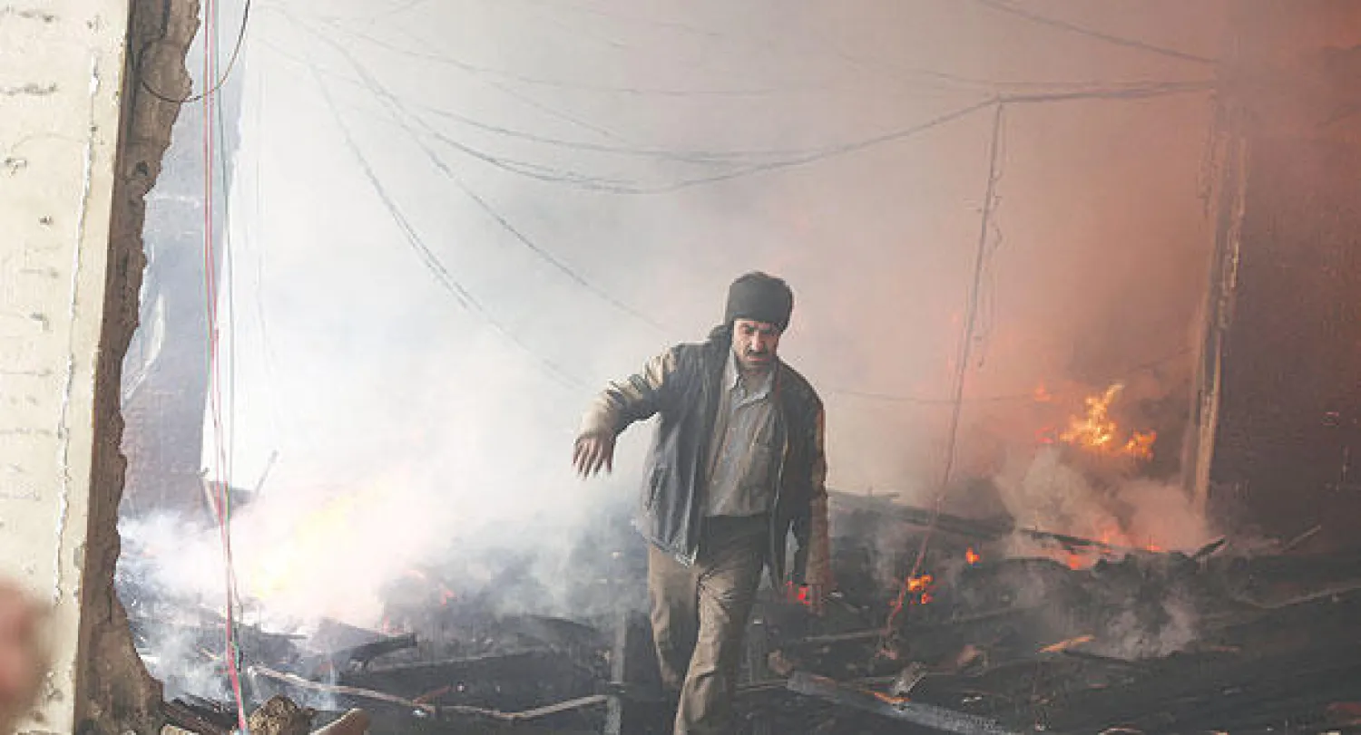 سوري يسير بين ركام مبنى مدمر بصورة كبيرة بفعل غارات طائرات النظام على مدينة دوما بريف دمشق