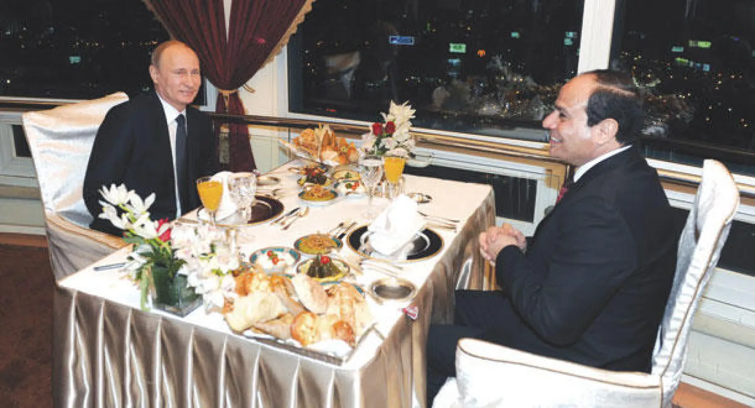 الرئيس المصري عبد الفتاح السيسي ونظيره الروسي فلاديمير بوتين خلال عشاء في برج القاهرة أمس (إ.ب.أ)