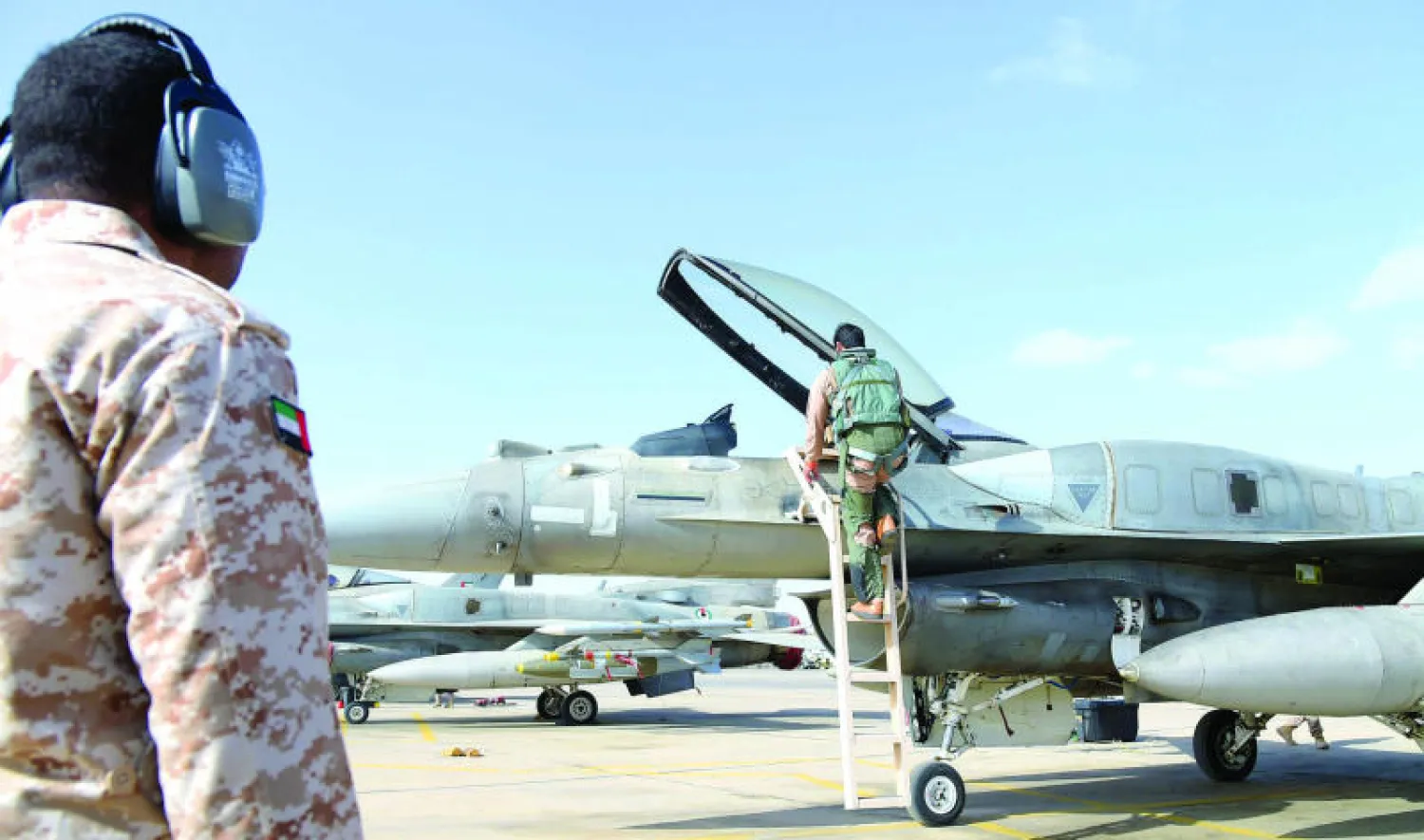طيار إماراتي يصعد إلى طائرته الـ{اف 16} في قاعدة سلاح الجو في الأردن قبل التوجه لشن غارات ضد تنظيم {داعش} أمس (وام)