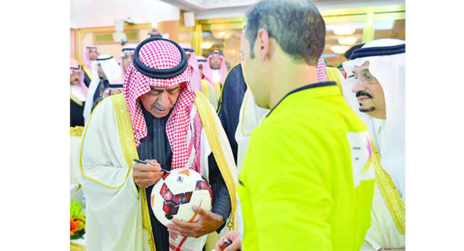 الأمير مقرن بن عبد العزيز يوقع على كرة المباراة خلال تقليد الخضير ميداليته