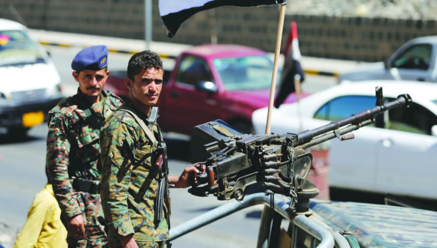 شرطيان يمنيان يقفان عند نقطة تفتيش في صنعاء أمس (رويترز)