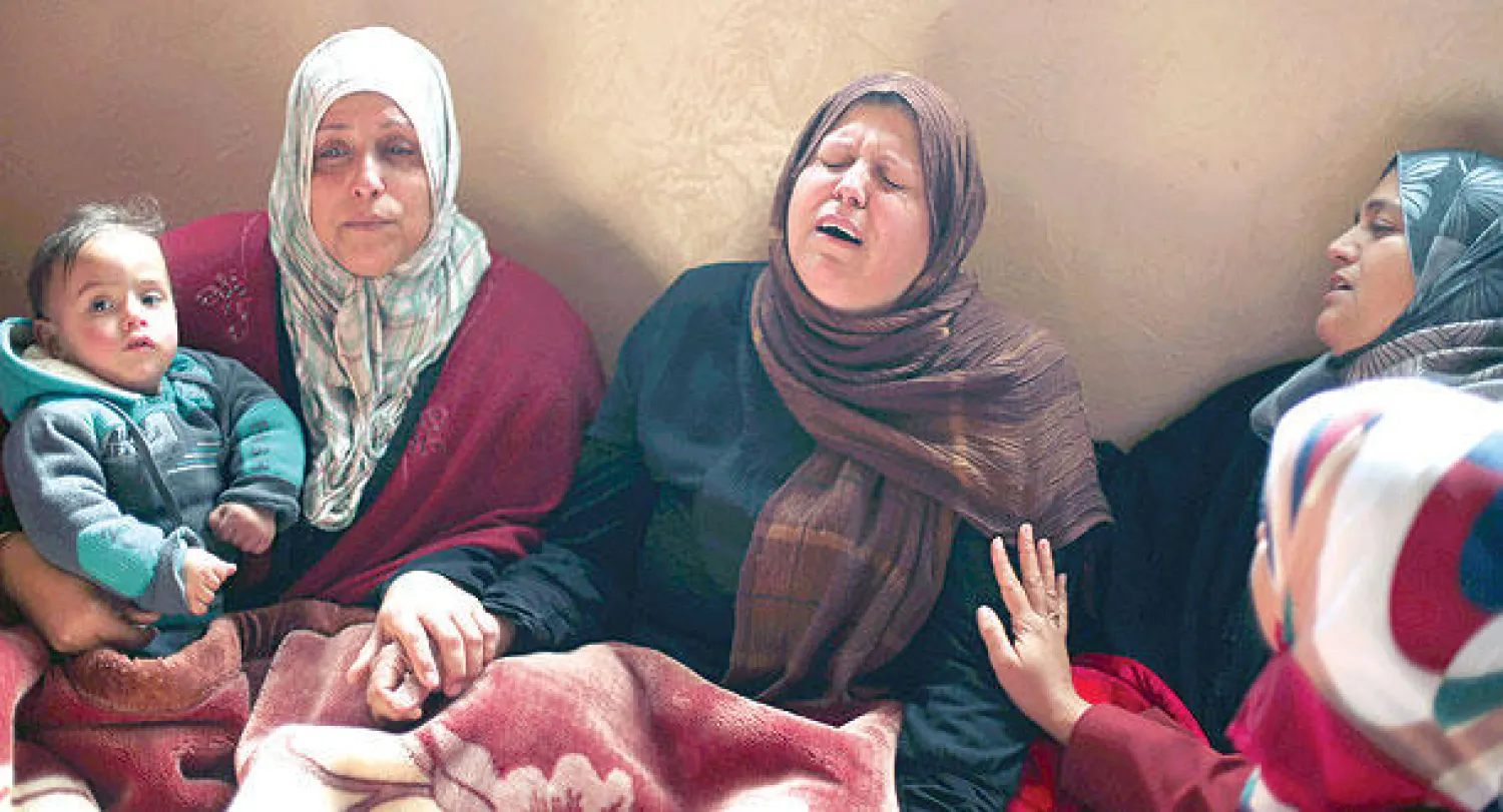 والدة الطفل عز الدين جاد الكفارنة تتقبل التعازي في وفاته داخل منزل العائلة في بيت حانون أمس (رويترز)